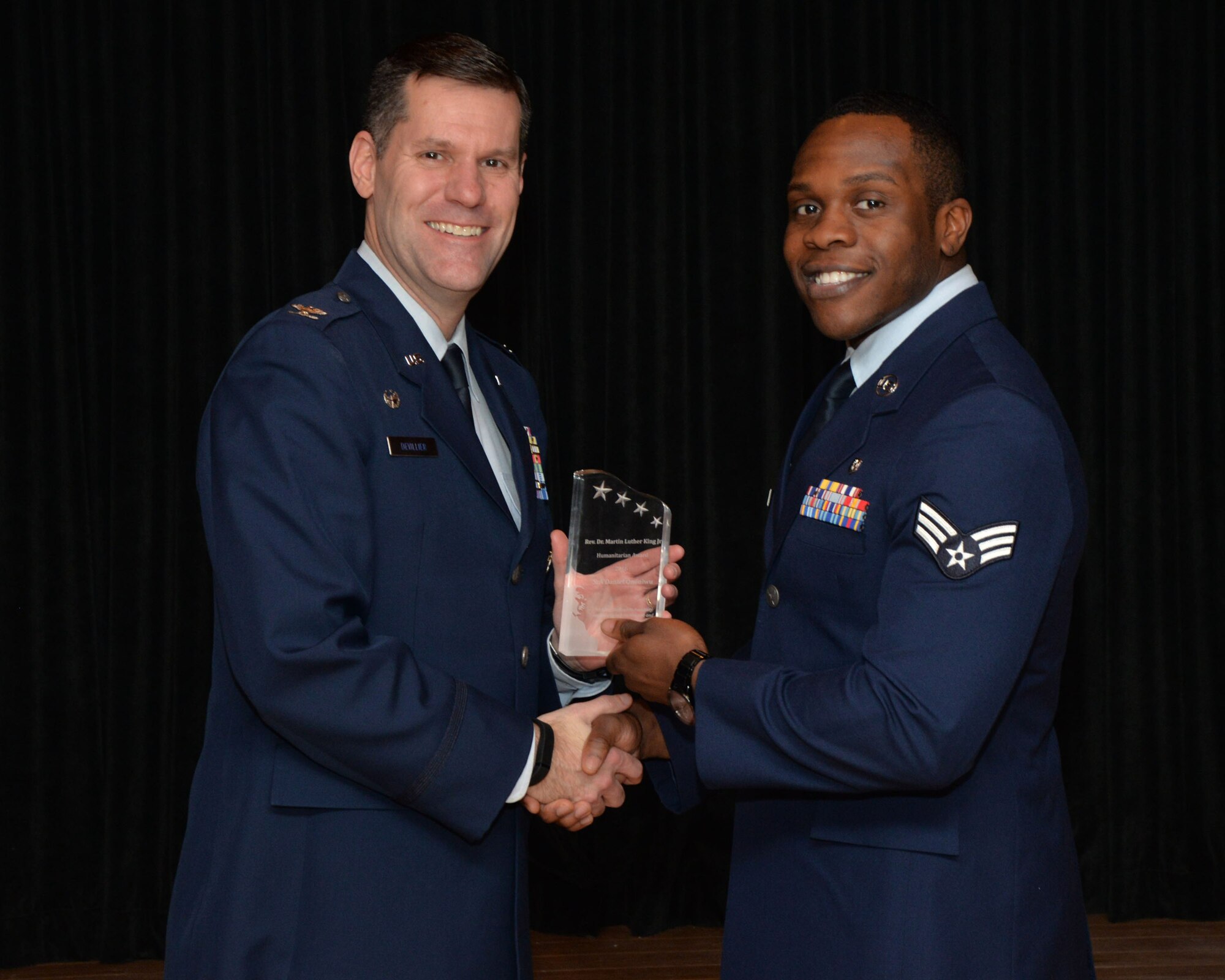 Col. John Devillier, 88th Air Base Wing commander, presents the 2016 Dr. Martin Luther King Jr. Humanitarian Award to Senior Airman Daniel Ononiwu, a public health technician with the 88th Aerospace Medicine Squadron, Public Health Flight. (U.S. Air Force photo/Michelle Gigante)