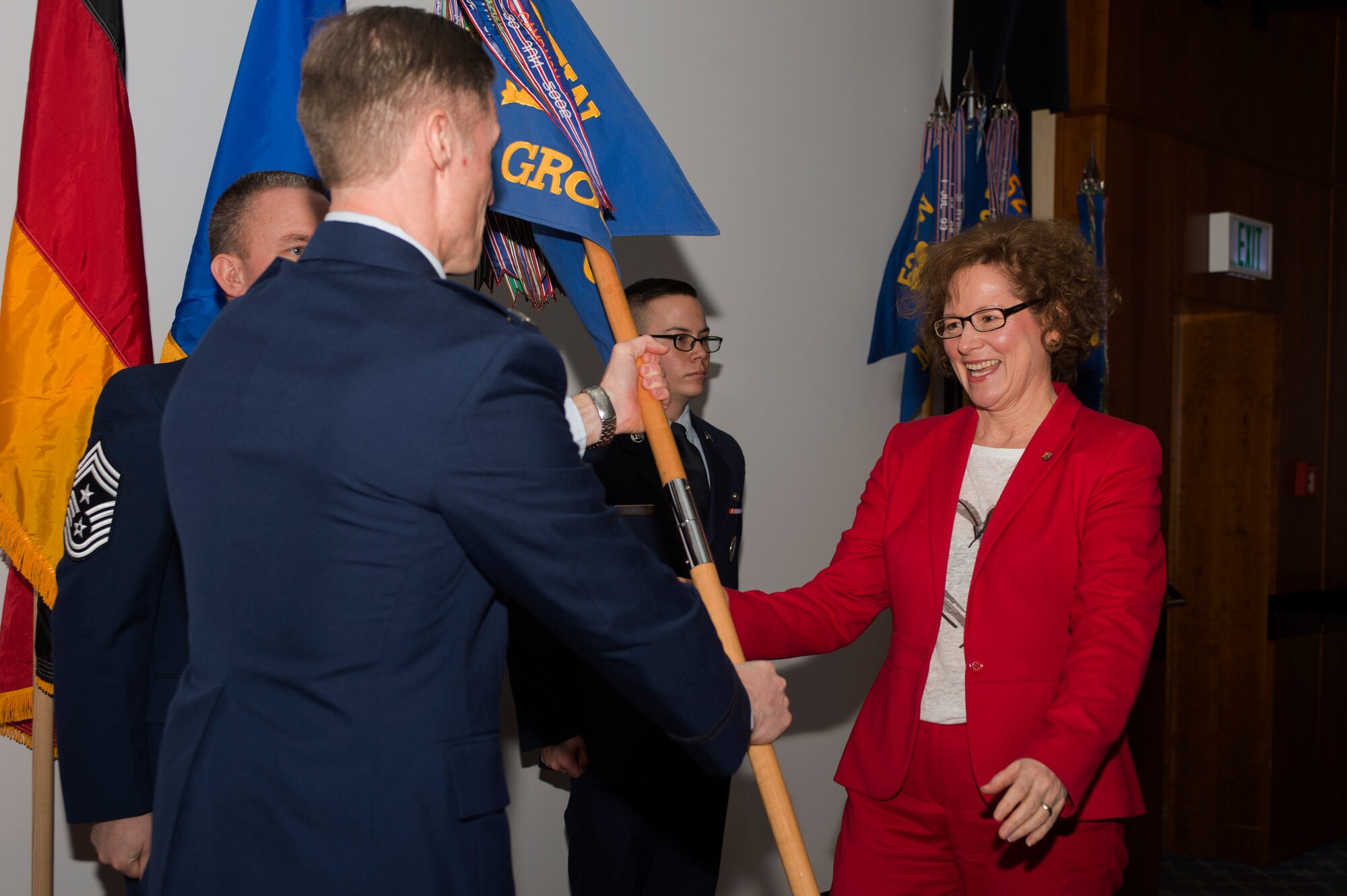 Dagmar Barzen, president of ADD Trier, rights, prepares to accept a guidon from U.S. Air Force Col. Michael Thompson, 52nd Operations Group commander, right, during the Honorary Commander's Program graduation ceremony at Club Eifel on Spangdahlem Air Base, Germany, Jan. 22, 2016. Barzen assumed honorary command of the 52nd OG as part of the program dedicated to enhancing relations between the American and German communities. (U.S. Air Force photo by Staff Sgt. Joe W. McFadden/Released)