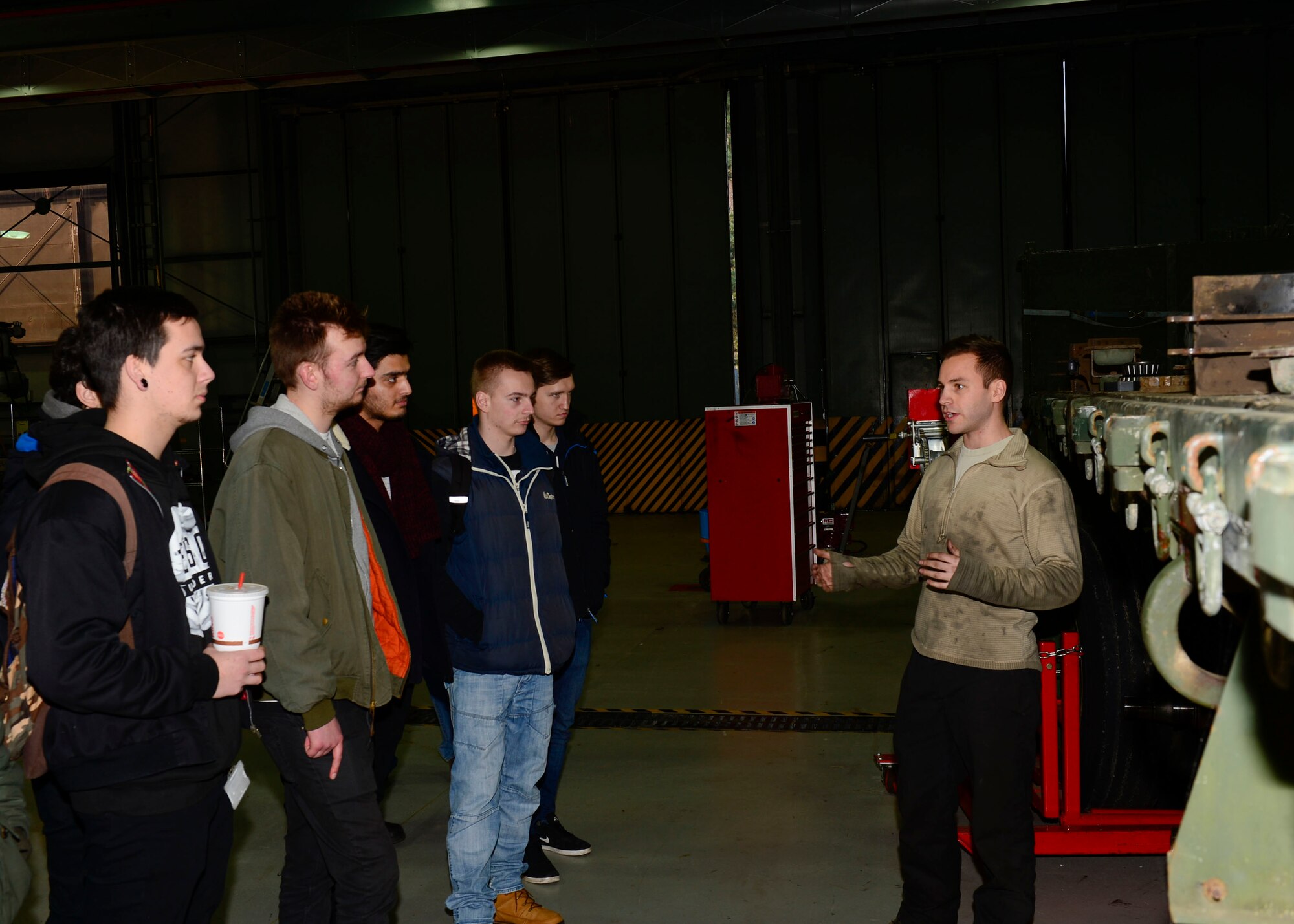 Suffolk New College students ask a vehicle maintenance Airman about daily operations in the 48th Logistics Readiness Squadron at Royal Air Force Lakenheath, England, Jan. 20, 2016. The 24 U.K. diagnostic and recertification students spent the afternoon touring the vehicle maintenance section to see what it would be like to work on American model cars. (U.S. Air Force photo by Senior Airman Nigel Sandridge/ Released)