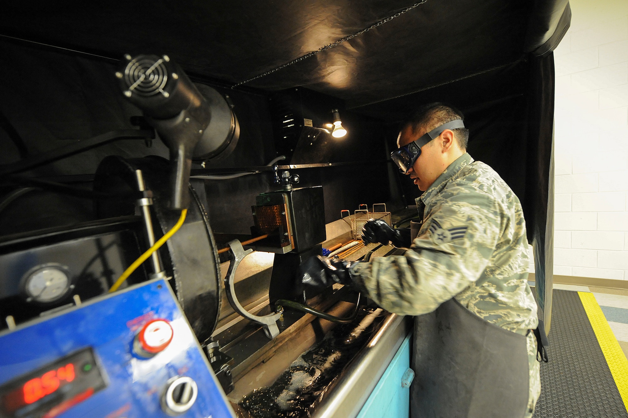 Senior Airman Max Bustamante, 22nd Maintenance Squadron non-destructive inspection Airman, runs an electric current through a KC-135 Stratotanker landing gear part, Jan. 25, 2016, at McConnell Air Force Base, Kan. NDI Airmen demagnetize aircraft parts so that the emanating magnetic field does not interfere with the compass on the aircraft while in flight. (U.S. Air Force photo/Airman Jenna K. Caldwell)  