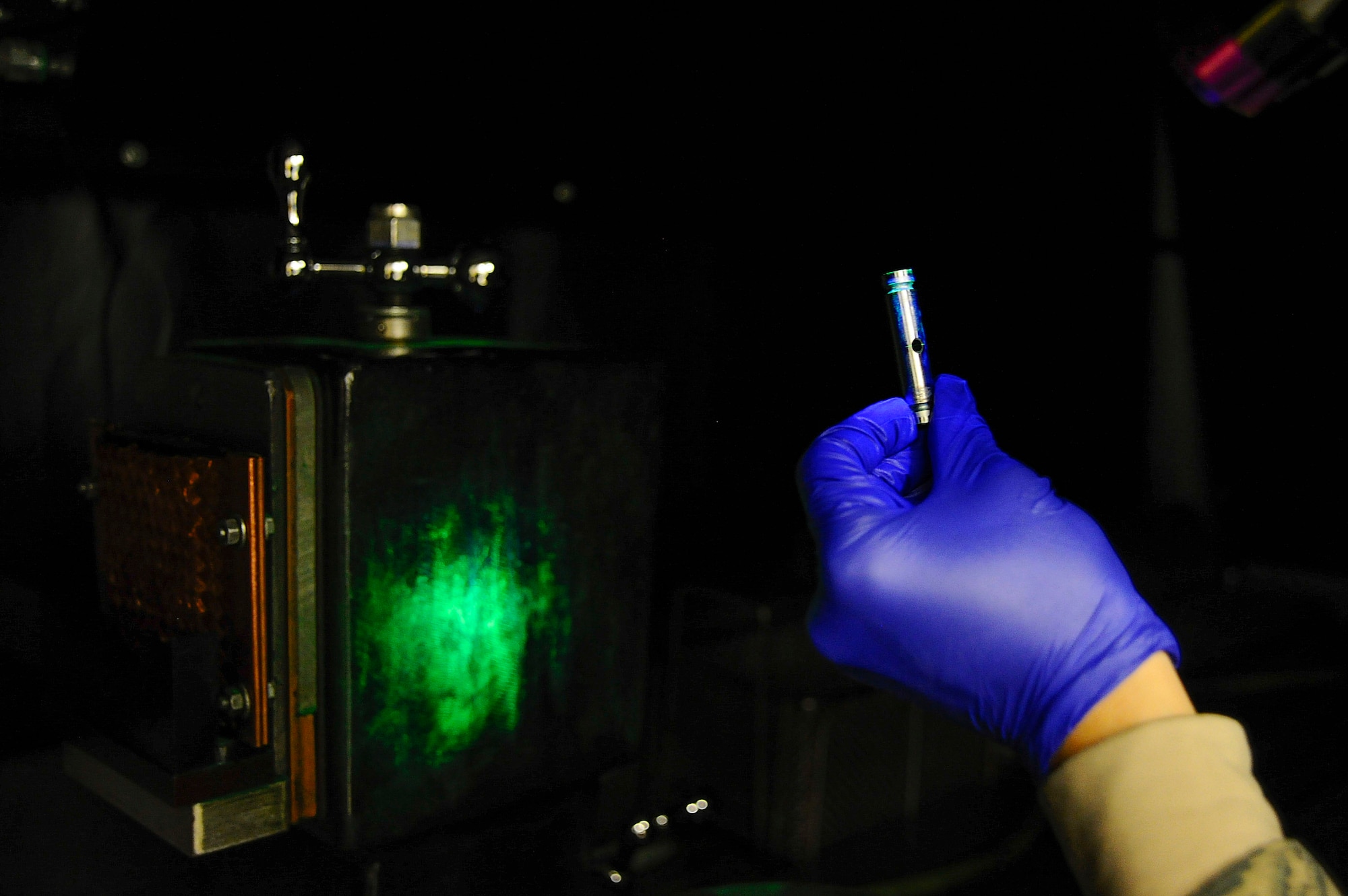 Senior Airman Max Bustamante, 22nd Maintenance Squadron non-destructive inspection Airman, inspects a fuel nozzle pin for damage under a blacklight, Jan. 25, 2016, at McConnell Air Force Base, Kan. Blacklights are used by NDI Airmen to look for defects that cannot be seen in regular lighting conditions. The backlight illuminates the applied phosphorus chemical that the parts are dipped in to highlight any damage the part may have. (U.S. Air Force photo/Airman Jenna K. Caldwell)  