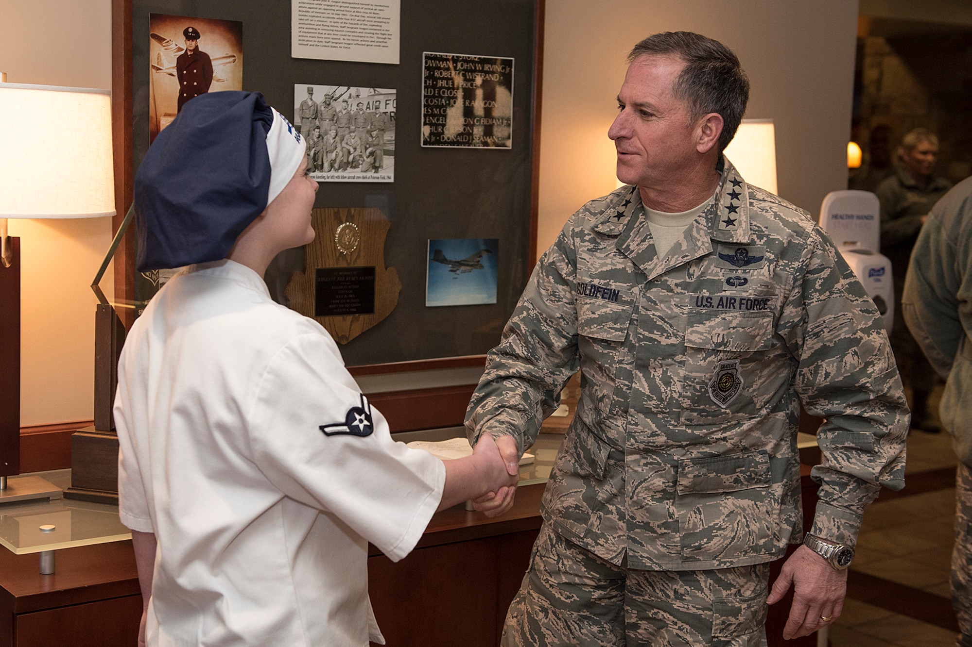 PETERSON AIR FORCE BASE, Colo. - Gen. David L. Goldfein, Air Force vice chief of staff, coins Amn Ashley Copeland, 21st Force Support Squadron food service apprentice at the Aragon Dinning Facility on Jan. 25, 2016. Goldfein had lunch with Peterson Airmen and discussed cyber operations and how the Air Force is more in line to accomplish future missions. (U.S. Air Force photo by Philip Carter)