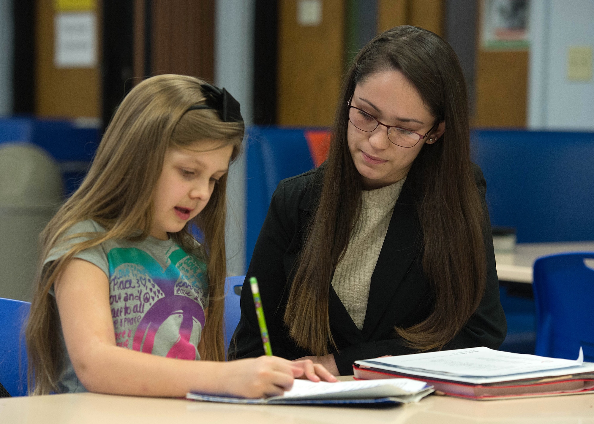 Caitlen Epperson, a senior at Bedford High School, assists Mackenzie White, 9, with her spelling homework at the Youth Center Jan. 26. Epperson was selected earlier this week as this year’s Hanscom Military Youth of the Year and will now move on to compete at the state level. (U.S. Air Force photo by Jerry Saslav)