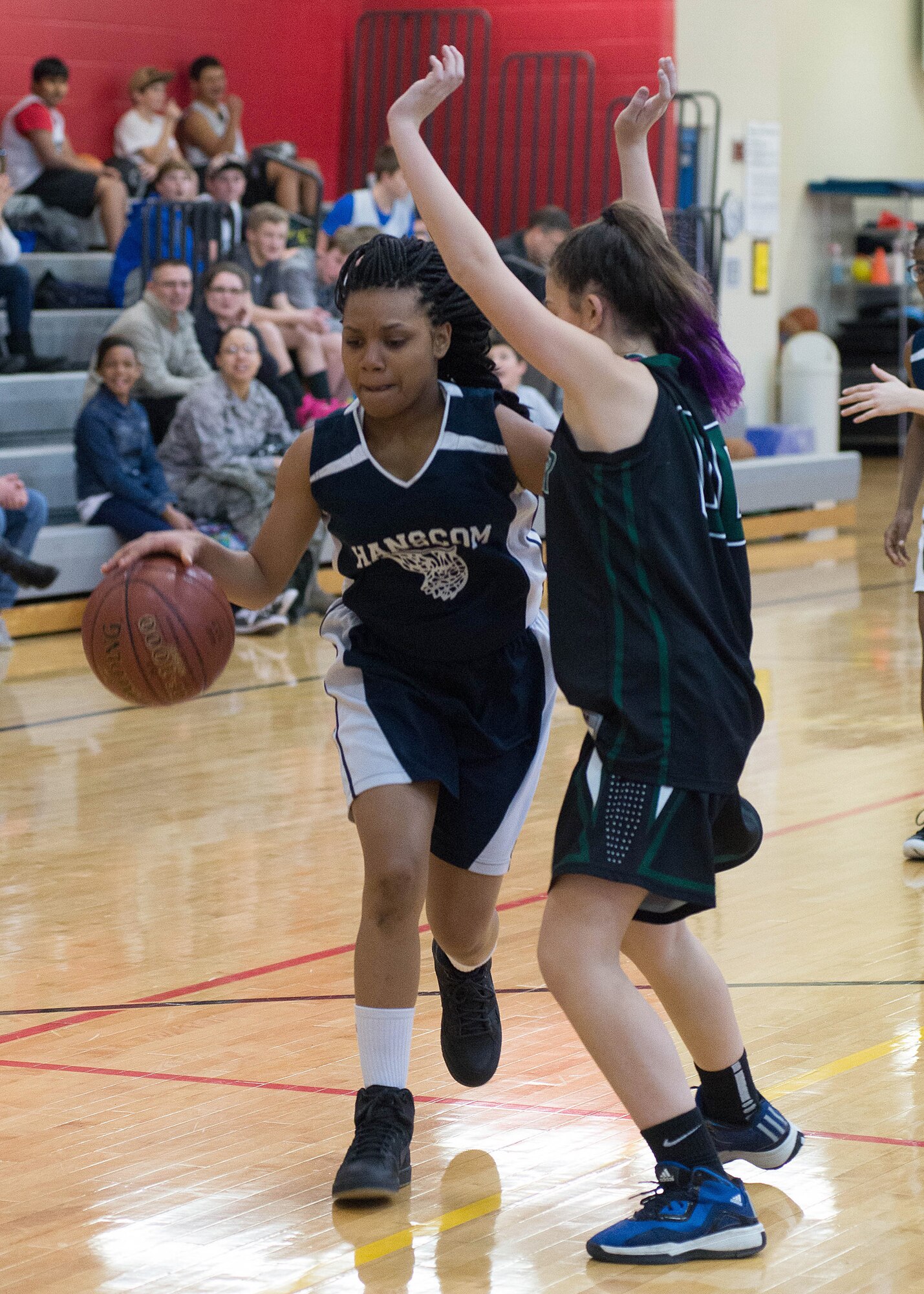 Hanscom Middle School's A'Knia Myers dribbles past Parker Charter School's Brooke Senatore during a middle school basketball game at the Hanscom Fitness and Sports Center Jan. 21. HMS Falcons lost to the visitors 39 to 27. (U.S. Air Force photo by Mark Herlihy)