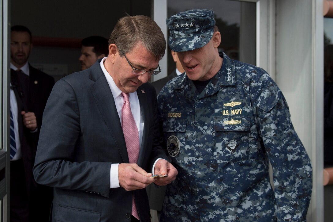 Navy Adm. Michael Rogers, commander of U.S. Cyber Command, presents Defense Secretary Ash Carter with a challenge coin as the secretary departs Cybercom after a visit to discuss matters of mutual importance, Jan. 27, 2016. DoD photo by Air Force Senior Master Sgt. Adrian Cadiz