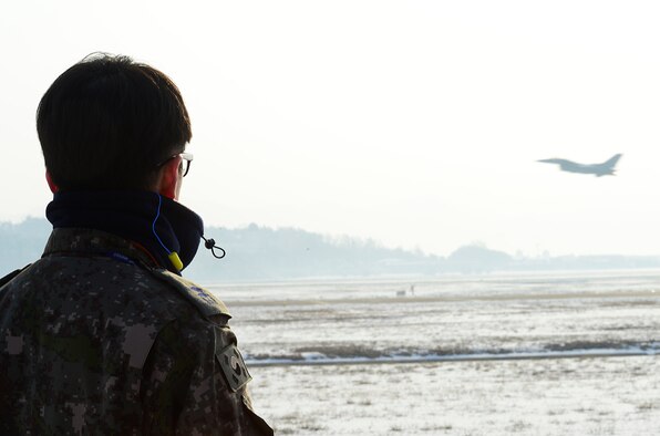 An airman from the South Korean air force watches an F-16 Fighting Falcon from the U.S. Air Force's 36th Fighter Squadron take off during exercise Buddy Wing 16-1 at Seosan Air Base, South Korea, Jan. 28, 2016. The Buddy Wing exercise is a combined fighter exchange program between the U.S. and South Korea to promote solidarity and mutual understanding of all executed operations. (U.S. Air Force photo/Senior Airman Kristin High)