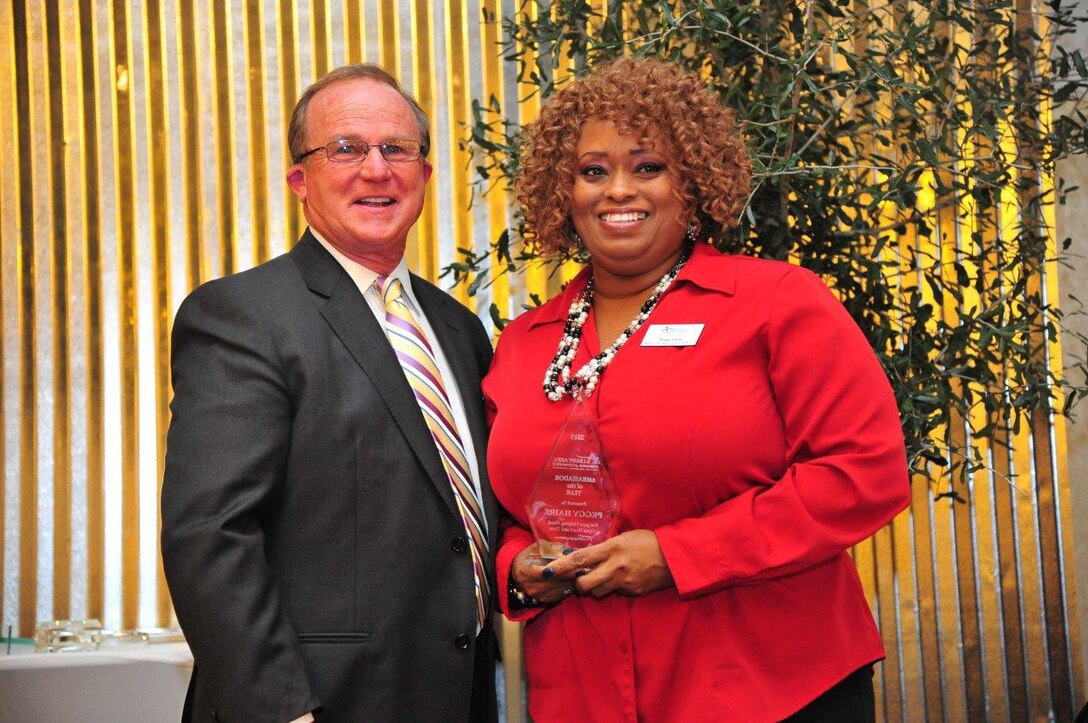 Peggy Haire, program analyst, Logistics Services Management Center, Marine Corps Logistics Command, receives the 2016 Ambassador of the Year award from Ed Newsome, incoming board chairman, Albany Area Chamber of Commerce, during the Albany Area Chamber of Commerce 106th annual meeting held at the Hilton Garden Inn and Conference Center in Albany, Georgia, Jan. 21.