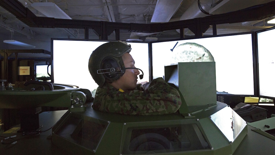 Japan Ground Self-Defense Force Cpl. Ishida, with the Western Army Infantry Regiment, looks out from the gun turret onto a simulated desert after successfully engaging targets during Exercise Iron Fist 2016 at Marine Corps Base Camp Pendleton, California, Jan. 26. The amphibious assault vehicle simulator offers the unique ability to train hands-on with the controls without requiring the resources needed to conduct training in the field. Iron Fist is an annual, bilateral amphibious assault exercise focused on strengthening of amphibious operations between the U.S. Marine Corps and the JGSDF.