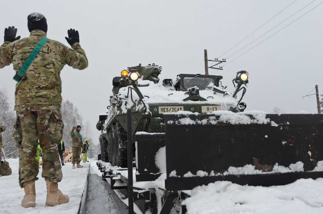 Soldiers ground guide the driver of a mortar carrier vehicle off the train during a railhead operation in support of Atlantic Resolve near Adazi, Latvia, Jan. 14, 2016. The soldiers are assigned to the 3rd Squadron, 2nd Cavalry Regiment, deployed from at Vilseck, Germany. Army photo by Staff Sgt. Steven Colvin