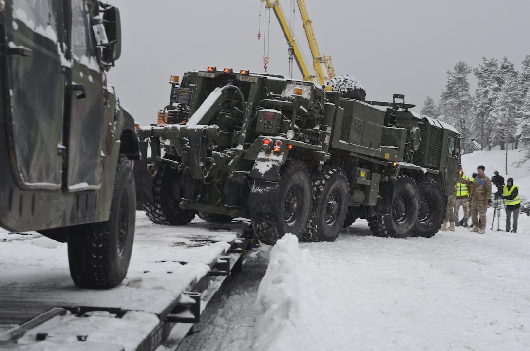 Soldiers guide an M984A4 heavy expanded mobility tactical truck, also known as a wrecker vehicle, as it is driven off the train and onto the platform during a railhead operation in support of Atlantic Resolve near Adazi, Latvia, Jan. 14, 2016. Army photo by Staff Sgt. Steven Colvin