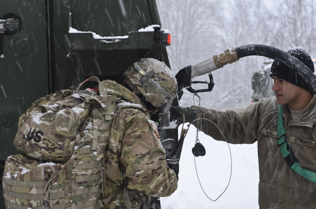 Army Sgt. Eric Nickels, left, checks the fuel level of an M1126 Stryker combat vehicle as Army Sgt. Puello fills it up during a railhead operation in support of Atlantic Resolve near Adazi, Latvia, Jan. 14, 2016. Nickels and Puello are assigned to the 3rd Squadron, 2nd Cavalry Regiment, deployed from Vilseck, Germany. Army photo by Staff Sgt. Steven Colvin