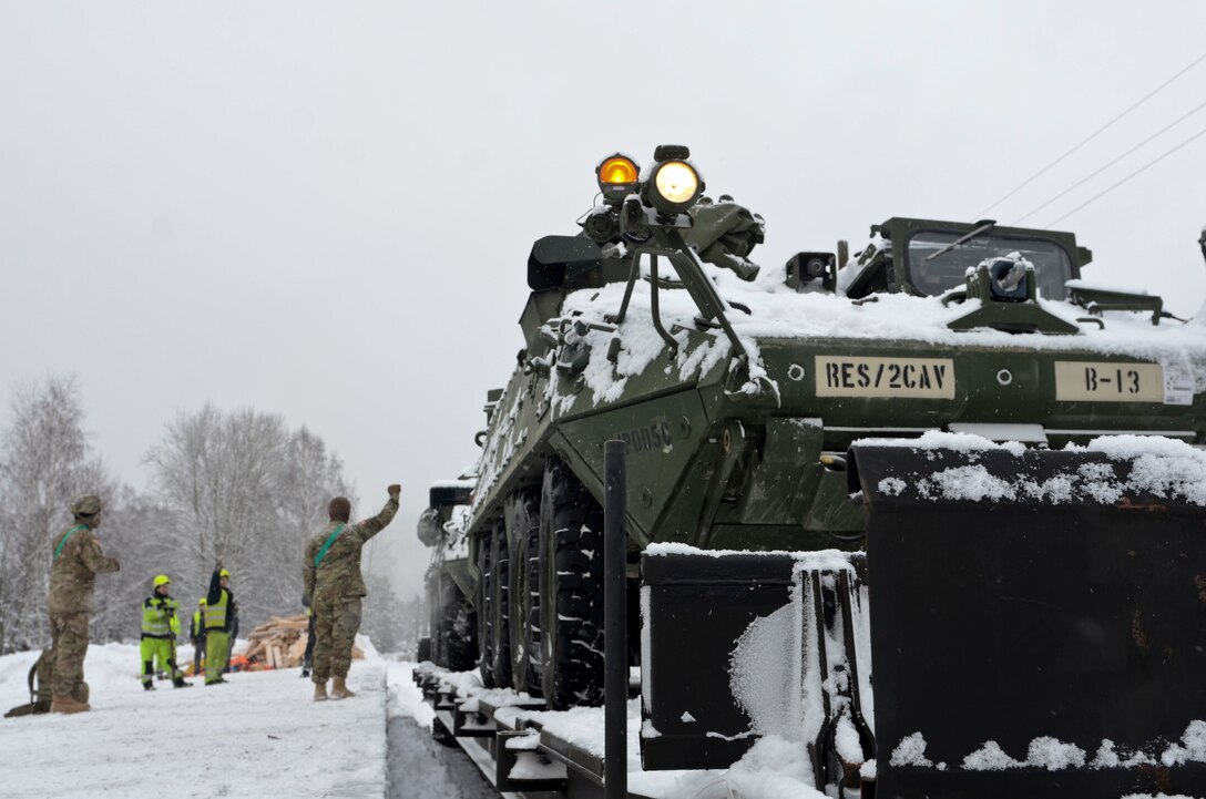Latvian rail workers and U.S. soldiers work together to offload military vehicles from the train during a railhead operation in support of Atlantic Resolve near Adazi, Latvia, Jan. 14, 2016. Army Staff Sgt. Steven M. Colvin