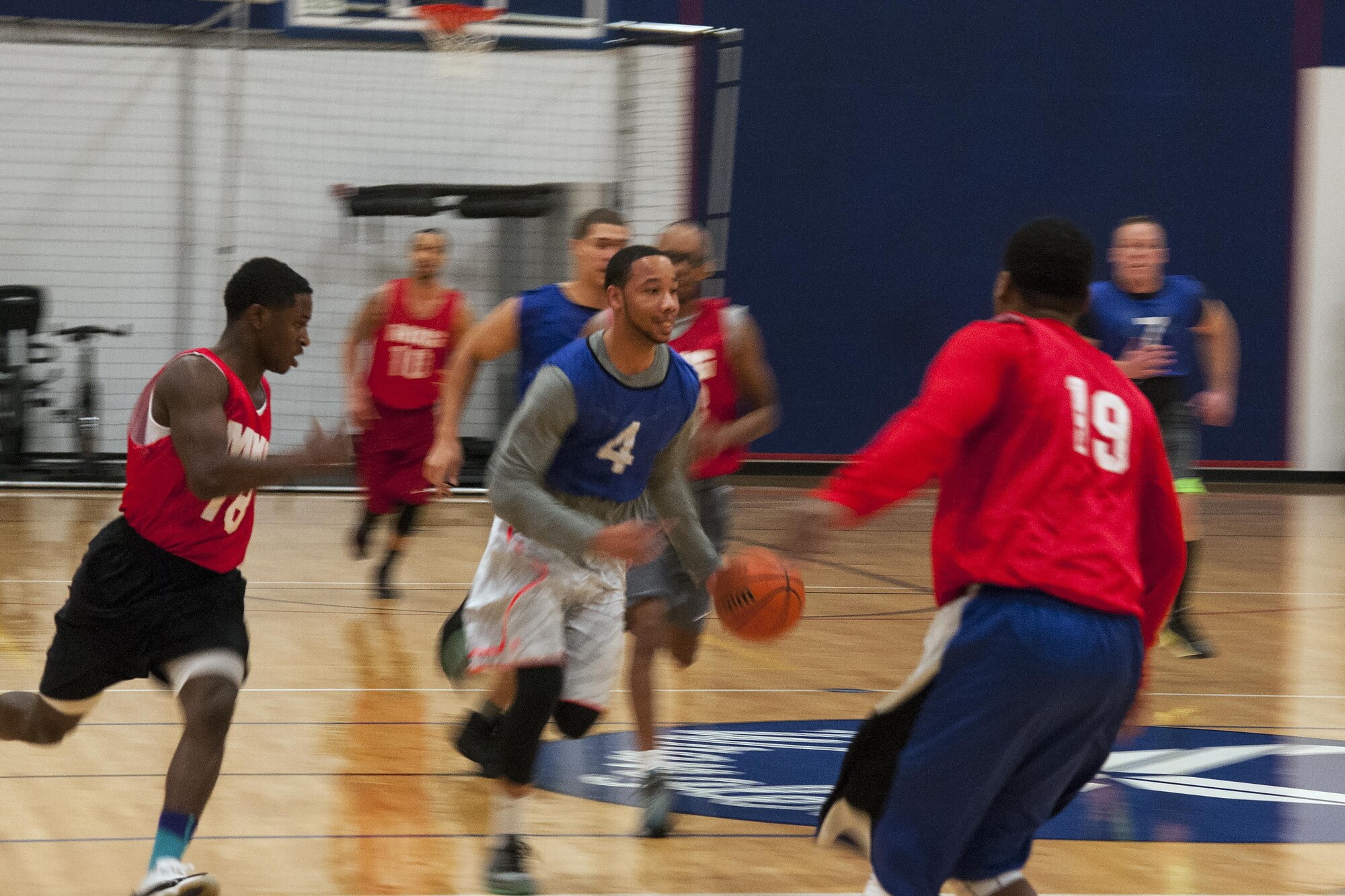 Anthony McBride, 90th Force Support Squadron, drives the ball down the court past 90th Maintenance Group defenders to make a layup during an intramural basketball game Jan. 26, 2016, on F.E. Warren Air Force Base, Wyo. The much-anticipated match-up brought two undefeated teams together, but FSS clenched the victory. (U.S. Air Force photo by Senior Airman Jason Wiese)