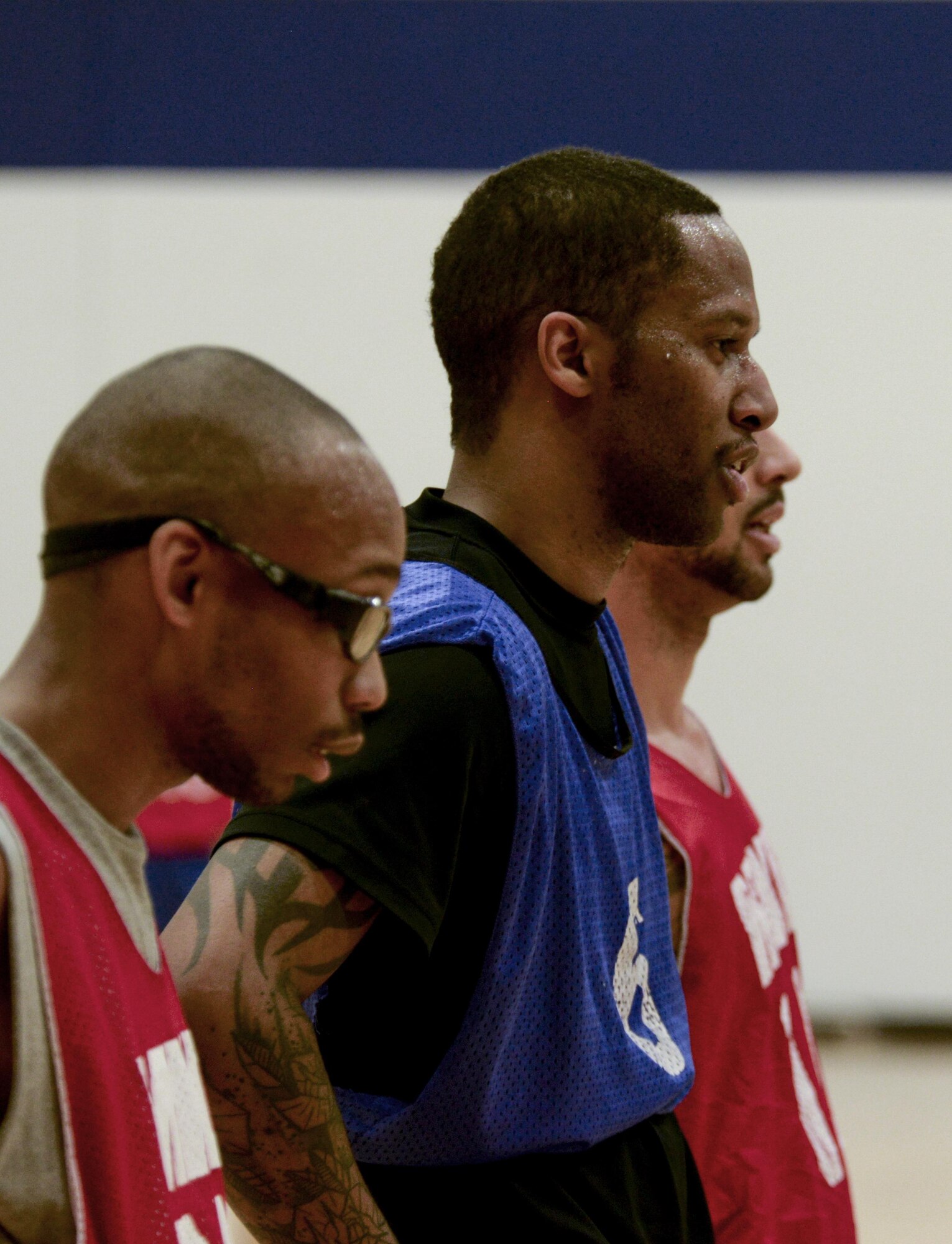 Players in the intrmural basketball game pitting the 90th Force Support Squadron against the 90th Maintenance Group take a breather before beside the lane during a free throw shot Jan. 26, 2016, on F.E. Warren Air Force Base, Wyo. The MXG team fought valiantly for points, but ultimately lost to FSS. (U.S. Air Force photo by Senior Airman Jason Wiese)