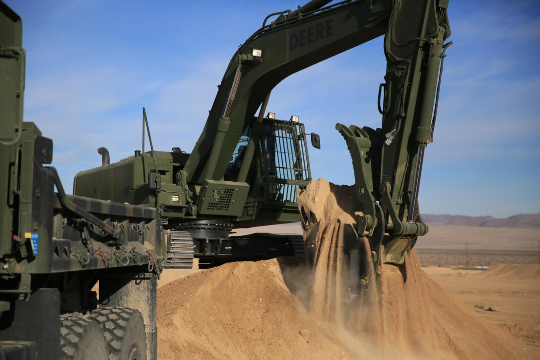Staff Sgt. John Vasquez, heavy equipment operations chief, Marine Wing Support Squadron 374, scoops sand with a John Deere 250 GR Hydraulic Excavator near the Strategic Expeditionary Landing Field, Jan. 22, 2016. Marines with MWSS-374 and MWSS-371 attended the two-week maintainer and operator courses, Jan. 11-22. (Official Marine Corps Photo by Cpl. Julio McGraw/Released)
