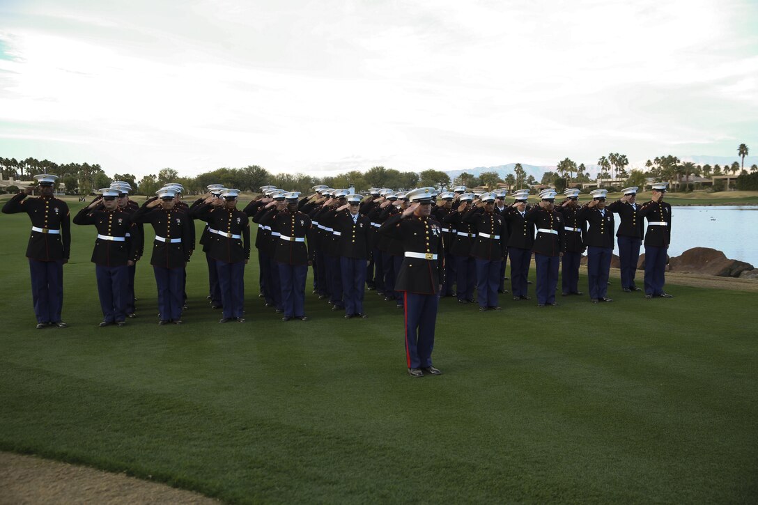 A formation of more than 50 Marine Corps Communication-Electronics School students led by Gunnery Sgt. Antonio Soto, company first sergeant, MCCES, salute during the presentation of the national colors and the playing of 'The Star-Spangled Banner’ during the Career Builder Challenge Military Appreciation Ceremony at the Tom Weiskopf Private Course located in the Professional Golfers Association of America Course West in La Quinta, Calif., Jan. 23, 2016. (Official Marine Corps photo by Cpl. Medina Ayala-Lo/Released)
