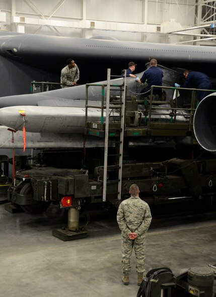 Members of the 2nd Maintenance Group loading standardization crew evaluate weapons load crew team members from the 96th Aircraft Maintenance Unit while they install a forward buffet fairing during the weapons load finals at Barksdale Air Force Base, La., Jan. 21, 2016. The competition was based on a point system, each team began with 1,000 points and then were scored on dress and appearance, a B-52 weapons system and air munitions test, equipment inspection, and weapons loading technical operations. (U.S. Air Force photo/Senior Airman Amanda Morris) 