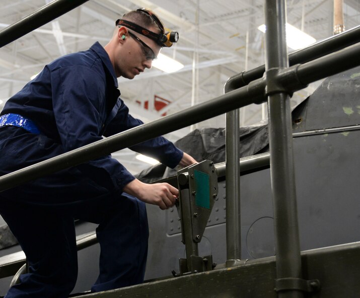 Airman 1st Class Pio Carranti, 20th Aircraft Maintenance Unit weapons load crew team member, positions an adjustable leaning board during the weapons load finals at Barksdale Air Force Base, La., Jan. 22, 2016. The leaning boards gave the crew a working platform for loading munitions. (U.S. Air Force photo/Senior Airman Amanda Morris)