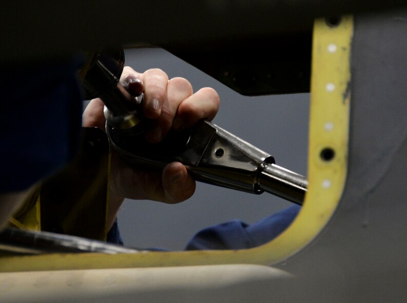 A weapons load crew team member from the 20th Aircraft Maintenance Unit removes a fitting from a pylon loaded with an AGM-86B nuclear training munition during the weapons load finals at Barksdale Air Force Base, La., Jan. 22, 2016. By removing the fitting the crew can attach the munition to the aircraft. (U.S. Air Force photo/Senior Airman Amanda Morris)