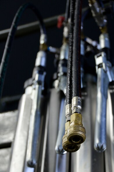 Airmen competing in a weapons load competition use grease guns to extend pylon wing adaptor pins by pumping grease through ports when attaching munitions to aircraft at Barksdale Air Force Base, La., Jan. 22, 2016. Weapons load crew teams must ensure that the grease guns are loaded with as much grease as possible and the tool is functioning properly. (U.S. Air Force photo/Senior Airman Amanda Morris)