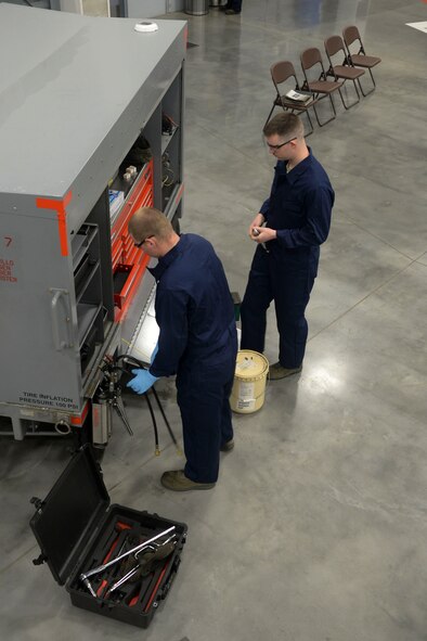 Weapons load crew team members from the 96th Aircraft Maintenance Unit gather tools before participating in the weapons load finals at Barksdale Air Force Base, La., Jan. 21, 2016. This team previously won weapons load crew of the quarter, and now competed for the title of top weapons load crew of the year. (U.S. Air Force photo/Senior Airman Amanda Morris)