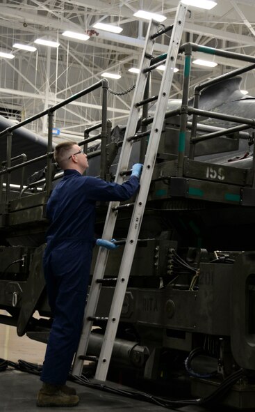 Senior Airman Jordan Flemister, 96th Aircraft Maintenance Unit weapons load crew team member, attaches a ladder to an MHU-196 trailer during the weapons load finals at Barksdale Air Force Base, La., Jan. 21, 2016. The trailer safely transports munitions such as the AGM-86/B, a nuclear training munition, to and from aircraft. (U.S. Air Force photo/Senior Airman Amanda Morris)