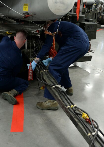 Weapons load crew team members from the 96th Aircraft Maintenance Unit remove the tow bar from an MHU-196 trailer during the weapons load finals at Barksdale Air Force Base, La., Jan. 21, 2016. The tow bar is required when moving the trailer to and from aircraft; once the tow bar is removed team members use a power control unit to maneuver the trailer into place. (U.S. Air Force photo/Senior Airman Amanda Morris)