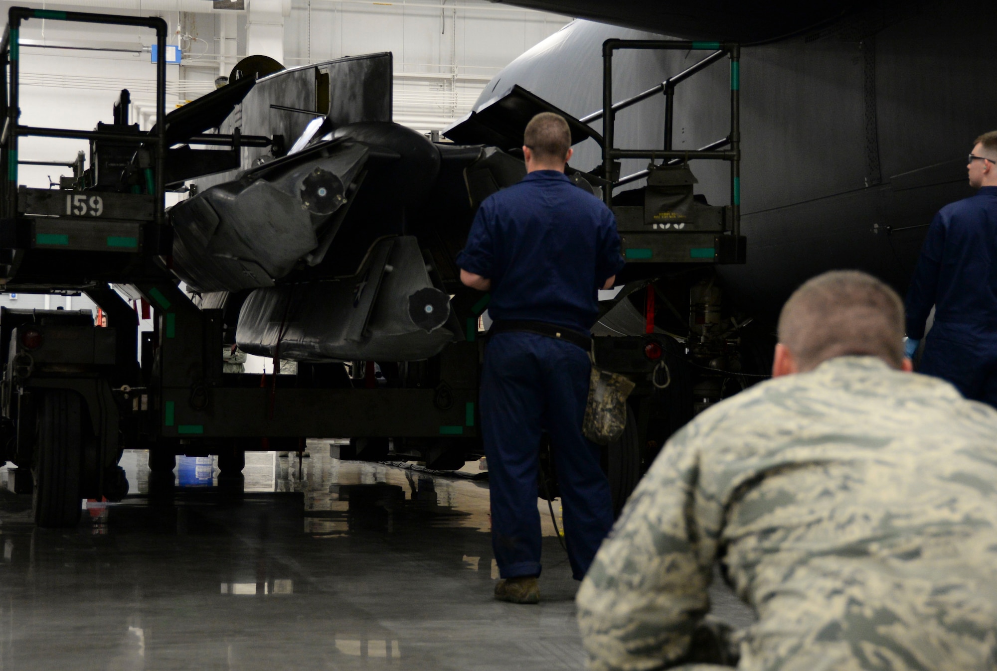 A member of the 2nd Maintenance Group loading standardization crew observes Senior Airman David Hansen, 96th Aircraft Maintenance Unit weapons load crew team member, operate a power control unit during the weapons load finals at Barksdale Air Force Base, La., Jan. 21, 2016. The PCU is a remote that controls movement for the MHU-196 weapon trailer. (U.S. Air Force photo/Senior Airman Amanda Morris)