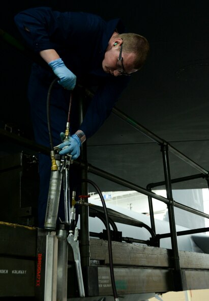 Senior Airman Brandon Barber, 96th Aircraft Maintenance Unit weapons load crew team member, grabs a grease gun during the weapons load finals at Barksdale Air Force Base, La., Jan. 21, 2016. Before the competition begins, the team must ensure that the grease guns are loaded with as much grease as possible and the tool is functioning properly in order to attach the munition to the aircraft. (U.S. Air Force photo/Senior Airman Amanda Morris)