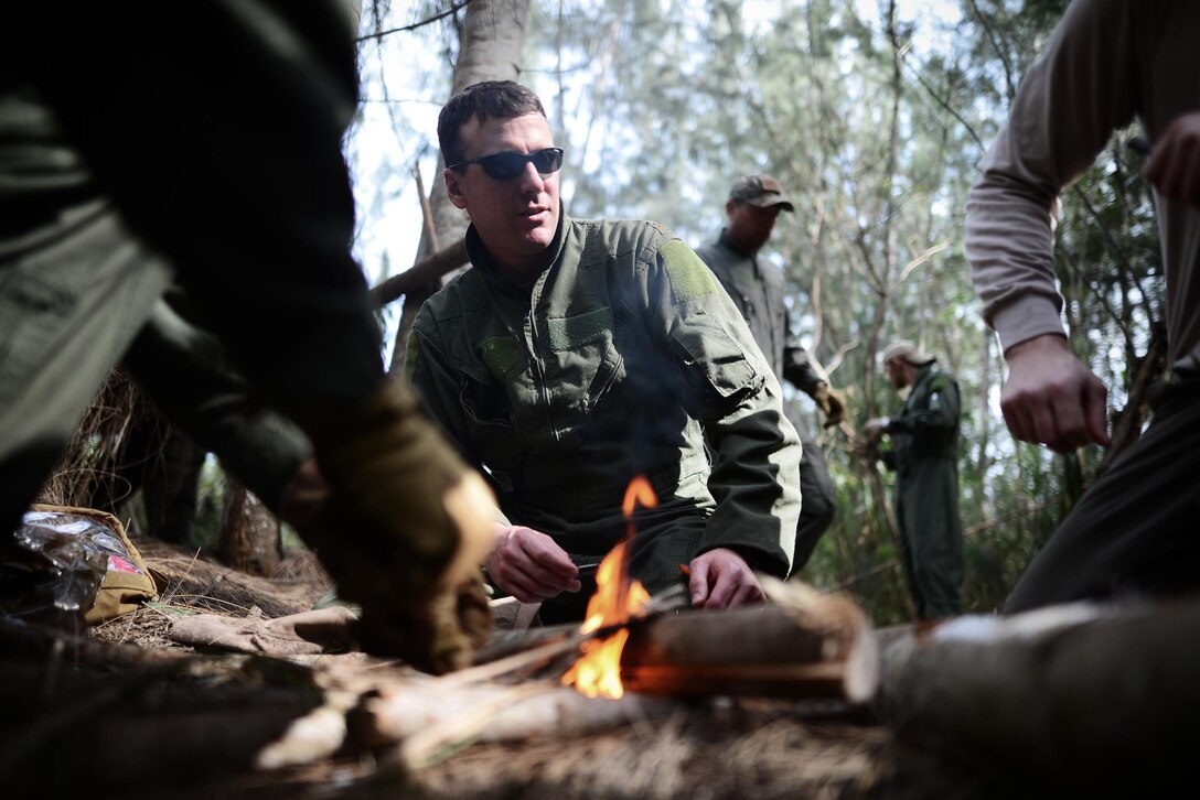 Air Force Maj. Dave Sumwalt, center, helps build a small fire during a combat and water survival training course on Homestead Air Reserve Base, Fla., Jan. 20, 2016. Sumwalt is a pilot assigned to the 101st Rescue Squadron. New York Air National Guard photo by Staff Sgt. Christopher S. Muncy