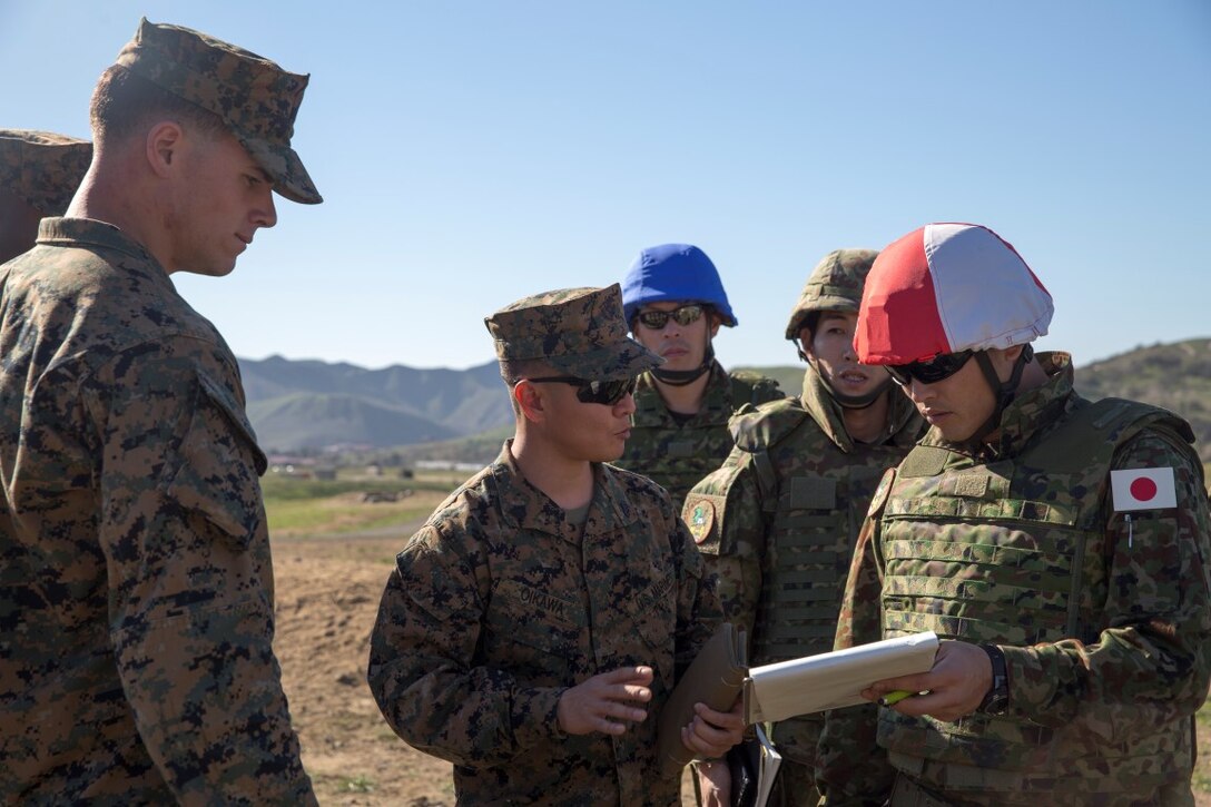 U.S. Marine Corps (center) Sgt. Shou Oikawa, Light Armored Vehicle with 3rd Light Armored Reconnaissance Battalion, translates for 1st Lt. Anthony Grandprey, weapons platoon commander with 1st Battalion, 4th Marine Regiment, as he explains the layout of Range 223B to his Japan Ground Self- Defense Force counterpart aboard Marine Corps Base Camp Pendleton, Calif., Jan. 25, 2016. This platoon attack exercise was the first of several training exercises that soldiers of the Japan Ground Self- Defense Force will be conducting as a part of Exercise Iron Fist 2016.