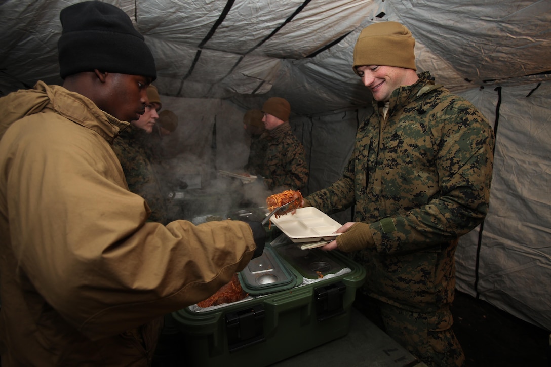 Lance Cpl. Sammy Grimes serves a Marine hot chow during cold weather training at the Marine Corps Mountain Warfare Training Center, Calif., Jan. 10, 2015. Hundreds of Marines participated in the cold weather training, enduring freezing temperatures during the two-week-long exercise in the Sierra Mountains. Grimes is a food service specialist at Marine Corps Base Camp Lejeune, N.C. (U.S. Marine Corps photo by Cpl. Jason Jimenez/Released)