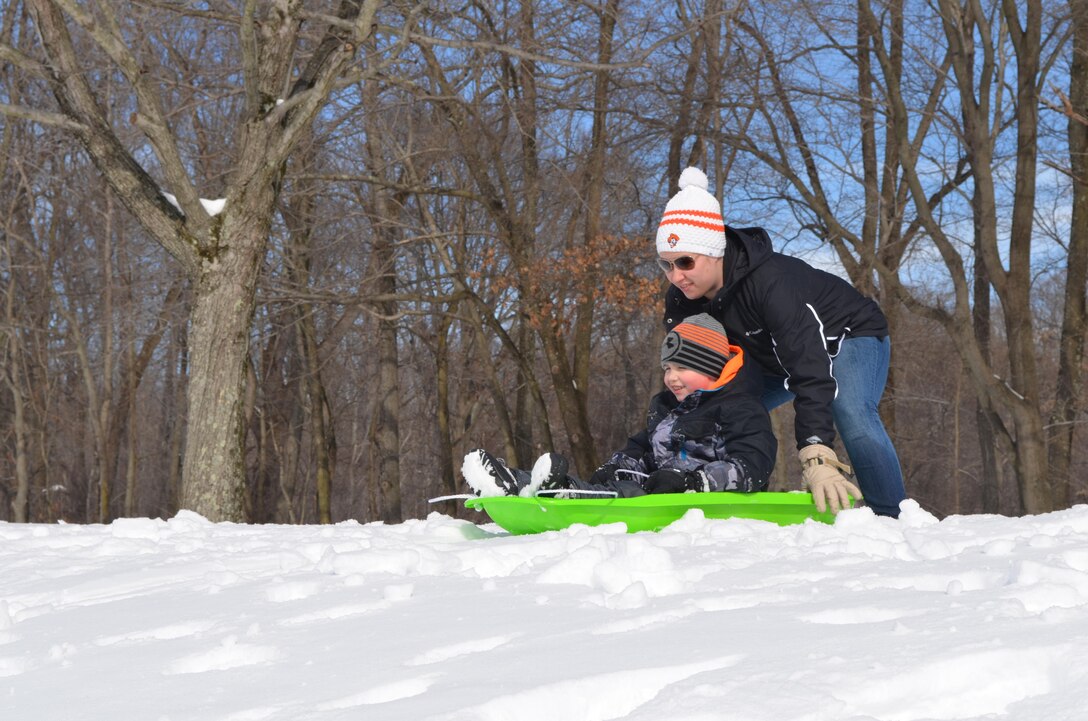 Caden, 7, and his mother Valerie Kanaack, play in the snow at Butler Stadium, enjoying the day off from school on Monday.