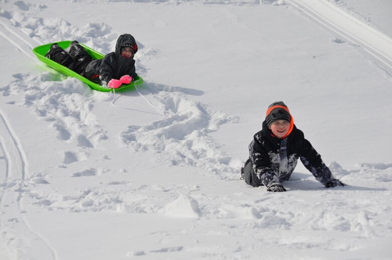 Kyla, 3, and Caden, 7, start the trek back up the hill after sledding down the hill at Butler Stadium on January 25.