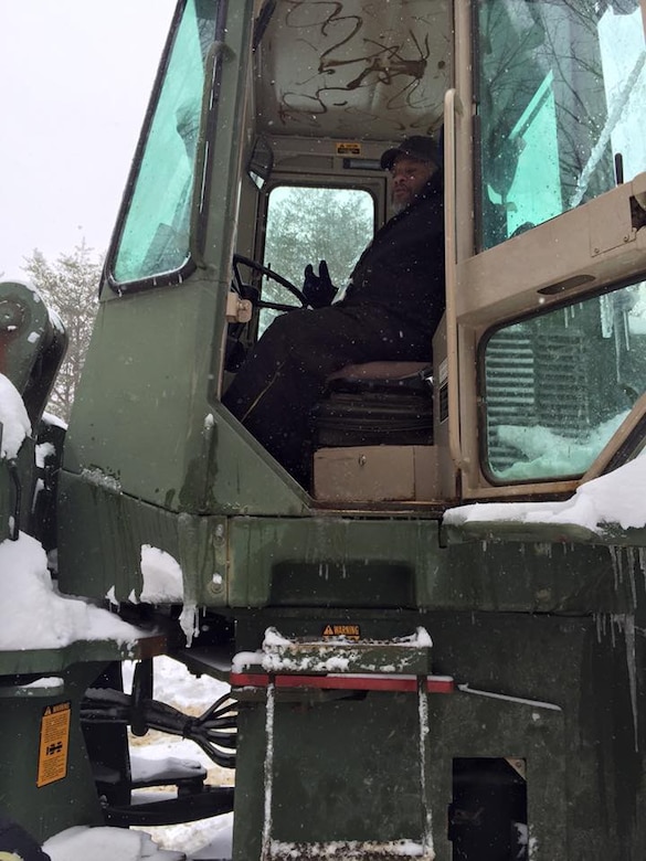 A worker takes a short break from removing snow.