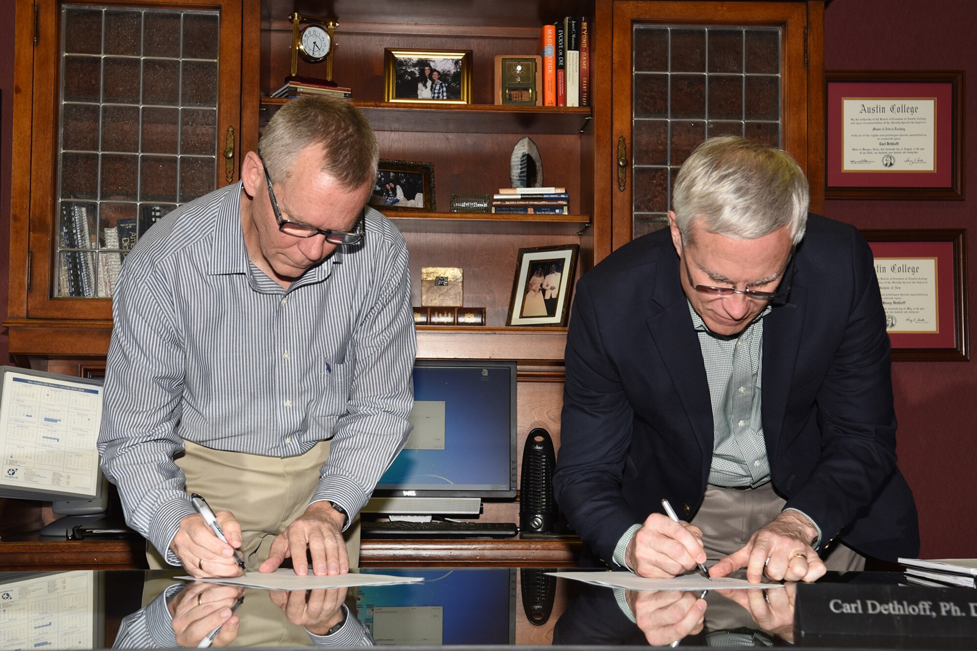 Thomas A. Baker Jr., 17th Force Support Squadron deputy director, and Michael K. Buck, Concho Valley Workforce Development Board executive director, sign a Memorandum of Understanding for family child care providers at the SAISD administrative building, San Angelo, Texas, Jan. 25, 2016. The MOU established a partnership between Goodfellow Air Force Base’s 17th Force Support Squadron Airman and Family Services Flight and CVWDB to provide suitable childcare for service members stationed at Goodfellow by selecting and training providers from licensed and registered child care homes within the San Angelo area. (U.S. Air Force photo by Staff Sgt. Laura R. McFarlane/Released)