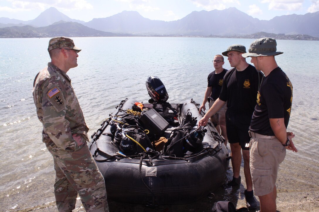 MARINE CORPS BASE HAWAII (Jan. 26, 2016) -- Divers from the  U.S. Army’s 7th Dive Detachment talk with Hononolulu District Commander Lt. Col. Christopher Crary about their dive survey in the waters of Kaneohe Bay. The dive survey for the U.S. Army Corps of Engineers, Honolulu District is in support of a Navy Dept. financed structural study of the historic Seaplane Ramps at Marine Corps Base Hawaii (MCBH) on Kaneohe Bay. The study, being conducted in-house by the District, provided an opportunity for the Corps to partner with the Army’s 7th Dive Detachment, 84th Engineer Battalion, 130th Engineer Brigade, which conducted the two day underwater site survey this week. 