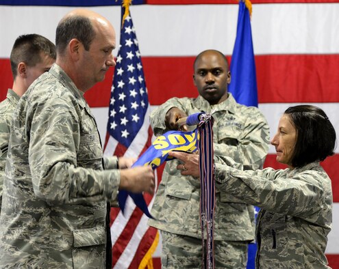 Col. Trevor Flint, 90th Maintenance Group commander, and Maj. Jacquie Sartori, 790th Maintenance Squadron commander, furl the recently inactivated 90th Maintenance Operations Squadron guidon Jan. 17, 2016, in the 90th MXG Maintenance High Bay on F.E. Warren Air Force Base, Wyo. The 90th MOS was redesignated to the 790th MXS. (U.S. Air Force photo by Senior Airman Jason Wiese)