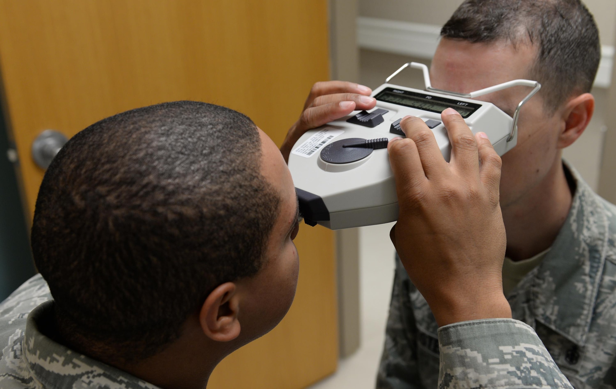Senior Airman Randolph Callender, 36th Medical Operations Squadron optometry technician, left, uses a pupilometer to measure the distance between the pupils of Tech. Sgt. Jeremy Foster, 36th MDOS optometry technician, Jan. 27, 2016, at Andersen Air Force Base, Guam. The pupilometer is used in place of a millimeter ruler for fitting eyeglasses. (U.S. Air Force Photo/Airman 1st Class Jacob Skovo)