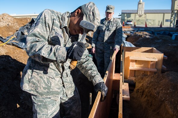 Senior Airman Nathan Coleman, 366th Civil Engineer Squadron structures specialist, drives rebar into the ground, Jan. 25, 2016, at Mountain Home Air Force Base, Idaho. The boards held together by the rebar will form a concrete base for the 1400 square foot building the engineers are building. (U.S. Air Force photo by Airman 1st Class Connor J. Marth/RELEASED)