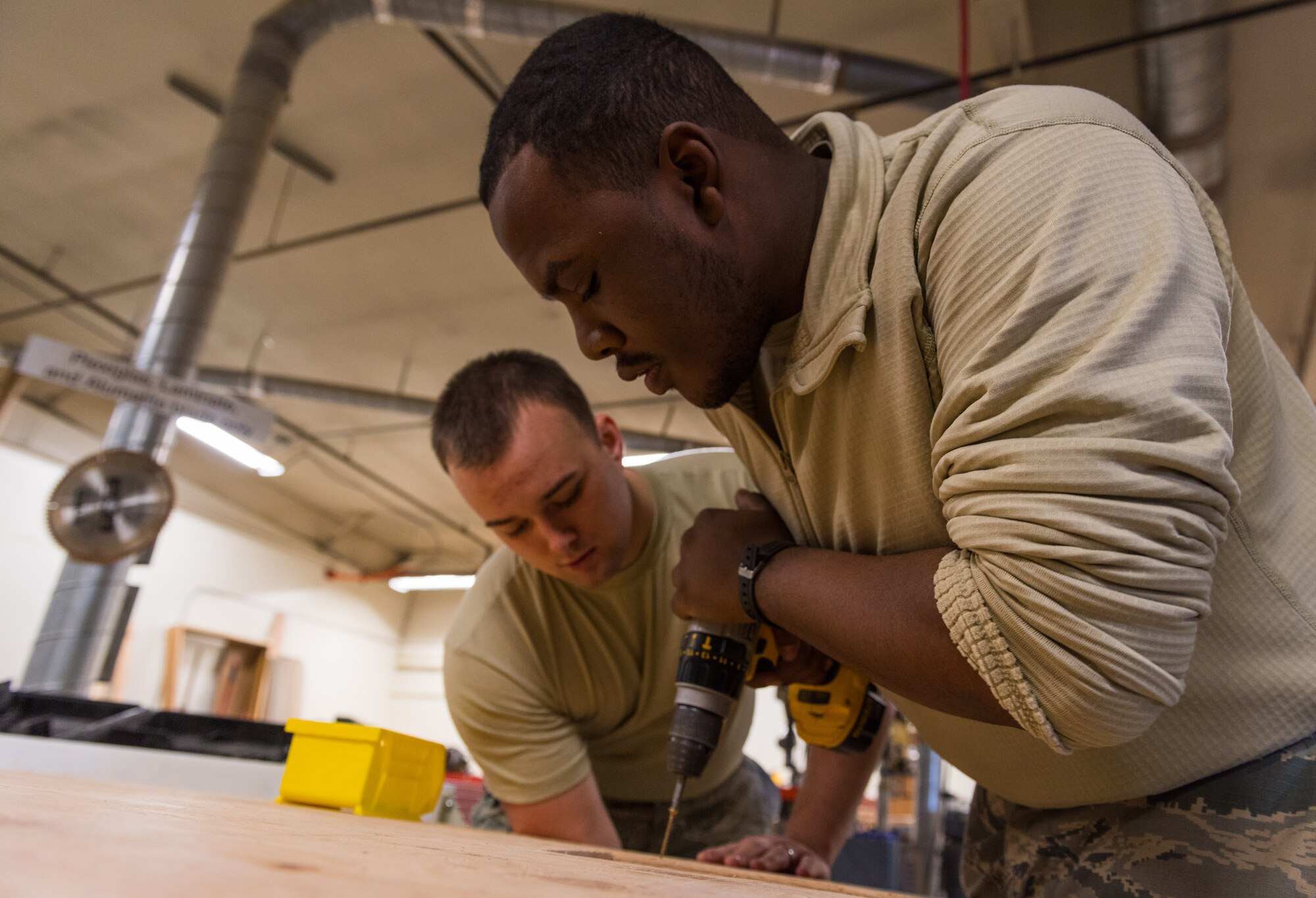 Senior Airman Jaylon Gordon, 366th Civil Engineer Squadron heating ventilation and air conditioning specialist, screws two boards together, Jan. 25, 2016, at Mountain Home Air Force Base, Idaho. The boards create part of the foundation forms used to hold concrete at the base of the building. (U.S. Air Force photo by Airman 1st Class Connor J. Marth/RELEASED)