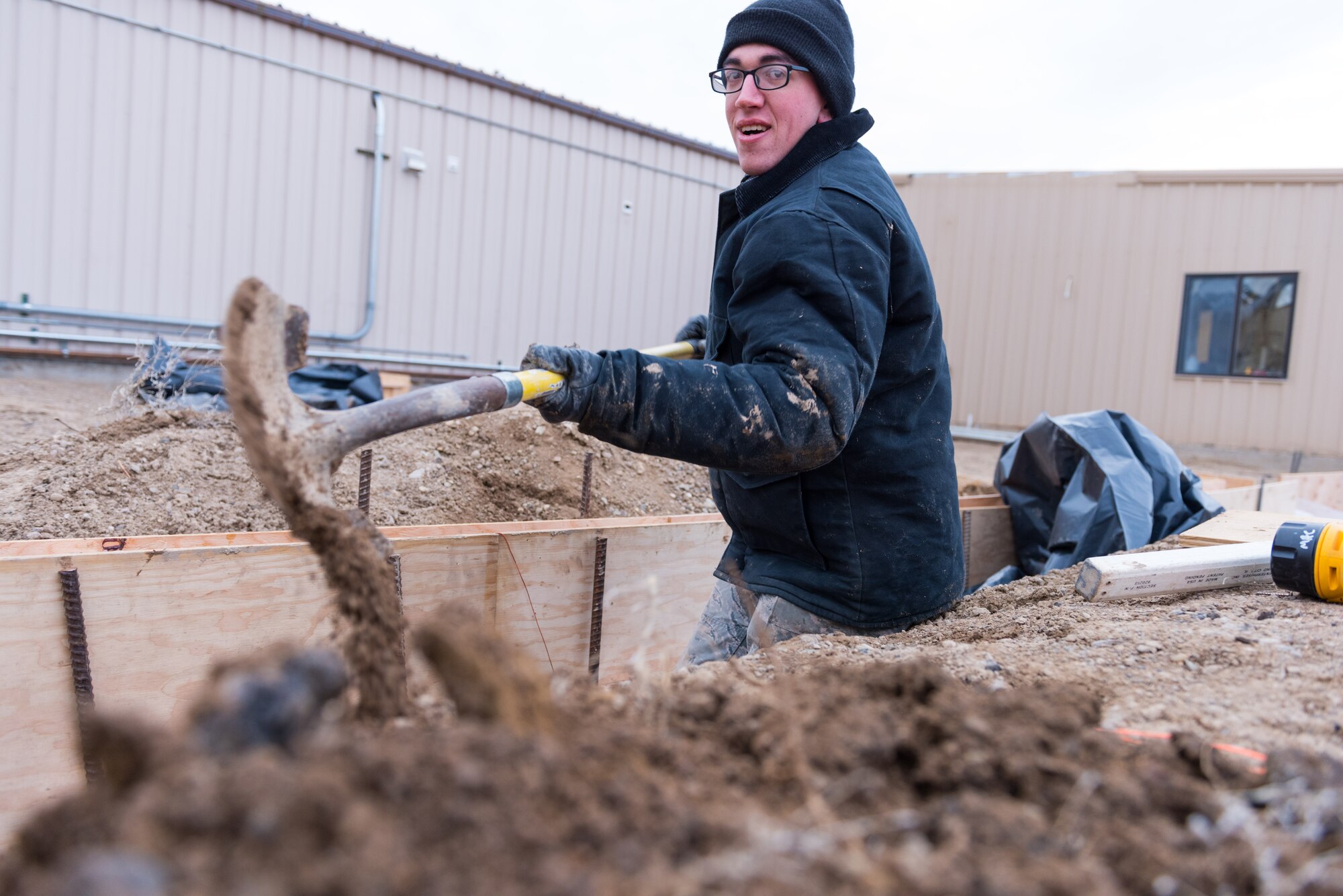 Airman 1st Class Cody Tetrick, 366th Civil Engineer Squadron pavements and heavy equipment specialist, widens a trench at a worksite, Jan. 22, 2016, at Mountain Home Air Force Base, Idaho. Tetrick and 34 other CES airmen are tasked with building a 1400 square foot training center as part of the annual Troop Training Project hosted by the squadron. (U.S. Air Force photo by Airman 1st Class Connor J. Marth/RELEASED) 