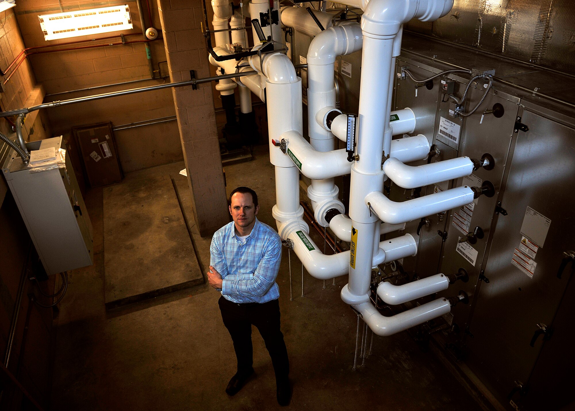 Christopher Arnold, 319th Medical Group facility manager, stands in a mechanical room that had been renovated with brand new energy and heating, ventilating and air conditioning equipment Jan. 27, 2016, on Grand Forks Air Force Base, North Dakota. The goal of the 319th MDG is to be more energy efficient and to provide a more comfortable environment for staff and patients. (U.S. Air Force photo by Senior Airman Xavier Navarro/Released)