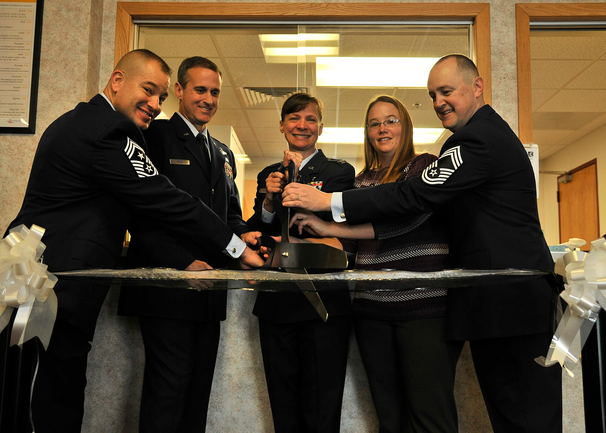 (left to right) Chief Master Sgt. Todd Krulcik, 319th Air Base Wing command chief, Col. Scott Reed, 319th ABW acting vice commander, Col. Therese Bohusch, 319th Medical Group commander, Amy McCauley, 319th MDG key spouse and Chief Master Sgt. Bryan Tuman, 319th MDG superintendent, cut the ribbon at the grand opening of the newly renovated Medical Treatment Facility on Grand Forks Air Force Base, North Dakota, Jan. 27, 2016. The $10 million renovation project included upgraded ventilation systems and a new main patient check-in area. (U.S. Air Force photo by Senior Airman Xavier Navarro/Released)