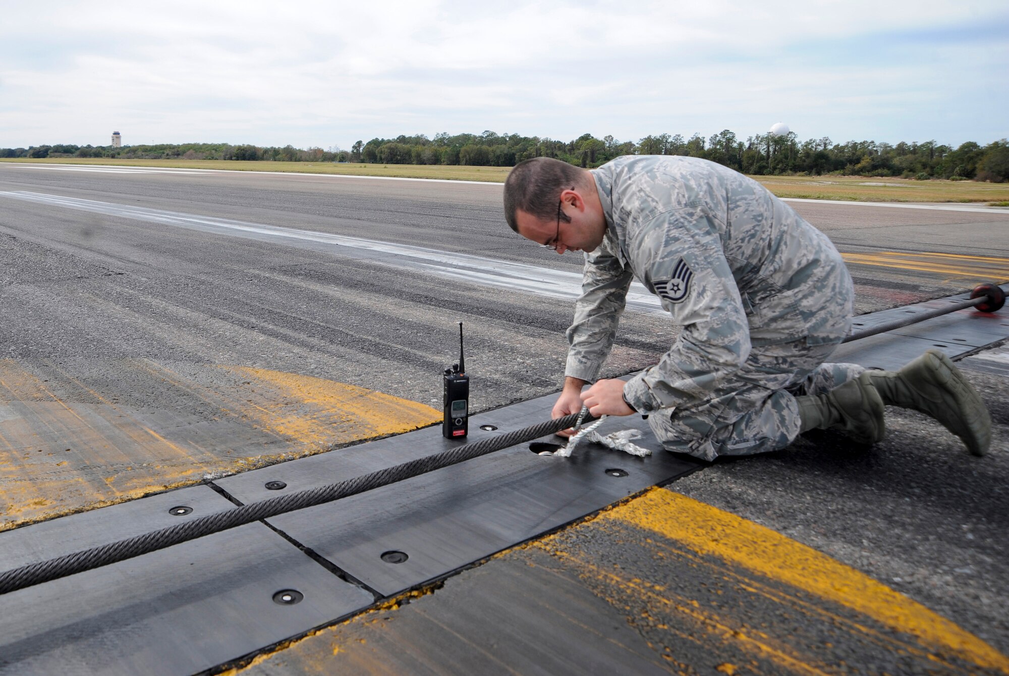 Staff Sgt. Michael David, an airfield management operations supervisor with the 6th Operations Support Squadron, removes a loose rope found on the flightline during a routine check at MacDill Air Force Base, Fla., Jan. 22, 2016. Airfield management Airmen must stay vigilant in order to detect a wide variety of safety hazards. (U.S. Air Force photo by Airman 1st Class Mariette M. Adams)