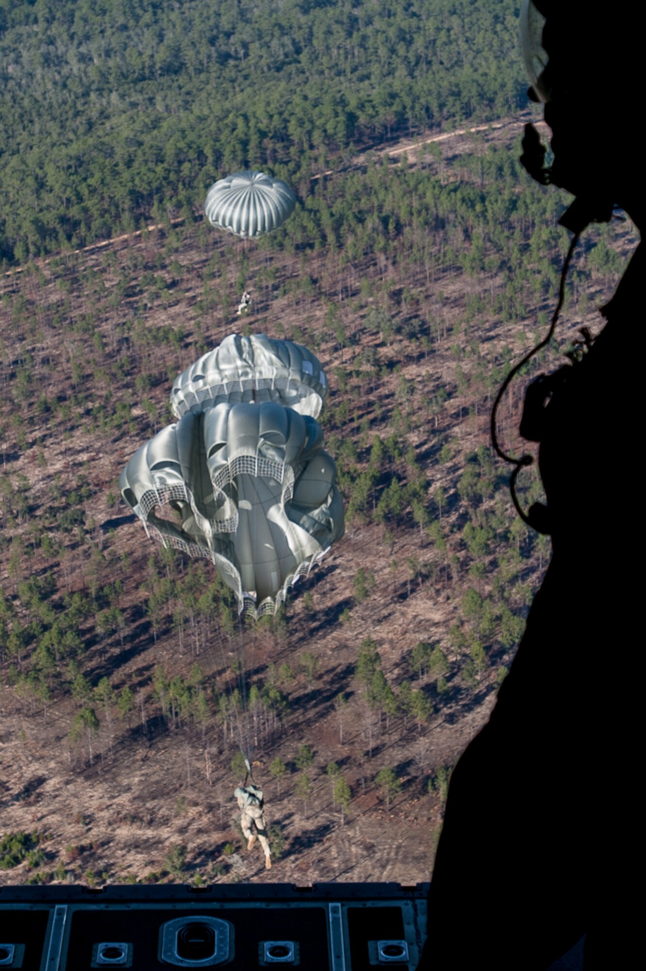 MC-6 parachutes unfurl over Eglin Air Force Base carrying soldiers and Green Berets assigned to the 7th Special Forces Group (Airborne) as they conduct a static line parachute jump onto an Eglin Air Force Base drop zone.  Green Berets and soldiers from the group conducted the parachute jump Jan. 12 to maintain their proficiency at airborne insertions.  (U.S. Air Force photo/Staff Sgt. William Waller)