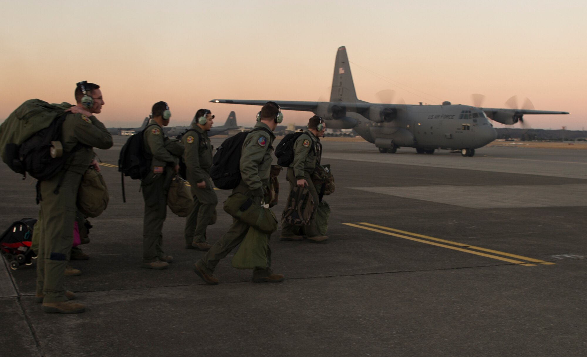 Loadmasters with the 36th Airlift Squadron head to C-130 Hercules at Yokota Air Base, Japan Jan. 25, 2016. On the flight, two new loadmasters successfully trained to supervise personnel drops, ensuring that they have experience handling the risks and challenges involved in preparation for real-world contingencies. (U.S. Air Force photo by Airman 1st Class Elizabeth Baker/Released)