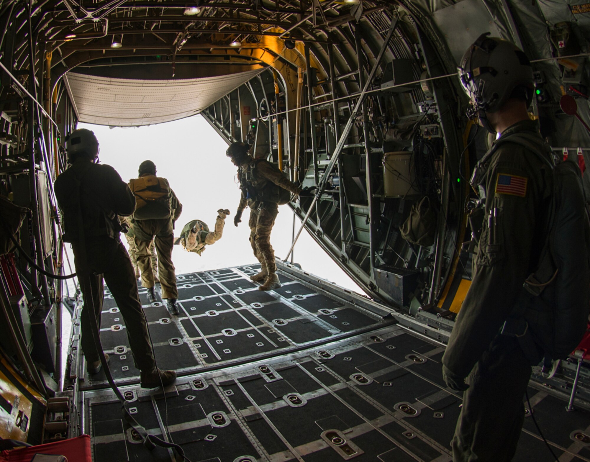 Loadmasters aboard a C-130 Hercules supervise a personnel drop over Yokota Air Base, Japan Jan. 25, 2016. Loadmasters are responsible for ensuring that aircraft cargo and passengers are transported safely and in a timely manner. This involves preparing rigging inside the aircraft and performing checks before and during the flight to ensure that all goes according to plan. (U.S. Air Force photo by Airman 1st Class Elizabeth Baker/Released)
