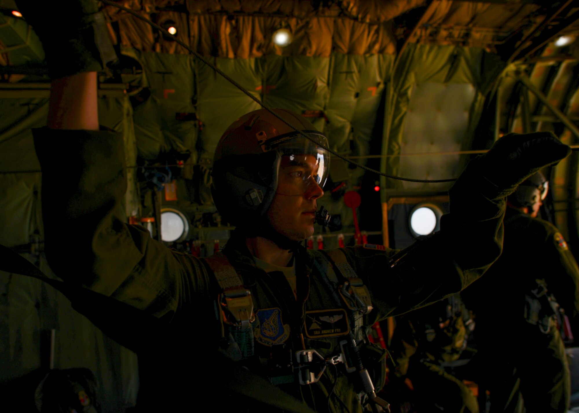 Senior Airman Andrew Fox, 36th Airlift Squadron instructor loadmaster with C-130 Hercules, supervises a personnel drop over Yokota Air Base, Japan Jan. 25, 2016. Loadmasters, who are responsible for the safety of cargo and personnel aboard aircraft, must stay alert for any complications which may occur in the cargo area. (U.S. Air Force photo by Airman 1st Class Elizabeth Baker/Released)