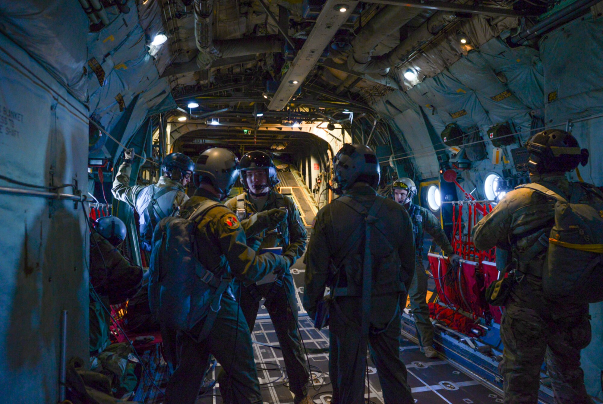 Loadmasters with the 36th Airlift Squadron prepare for a personnel drop out of a C-130 Hercules over Yokota Air Base, Japan Jan. 25, 2016. Loadmasters are responsible for ensuring that aircraft cargo and passengers are transported safely and in a timely manner, which involves preparing rigging inside the aircraft and performing checks before and during the flight to ensure the safety of personnel and equipment. (U.S. Air Force photo by Airman 1st Class Elizabeth Baker/Released)
